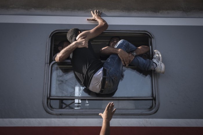 Sergey Ponomarev, del 'The New York Times', ha sido reconocido con el primer premio de la categoría de Historias de Temas Generales con esta foto de un grupo de refugiados intentando subir a un tren hacia Zagreb, desde Tovarnik, en Croacia. SERGEY PONOMAREV (AP)
