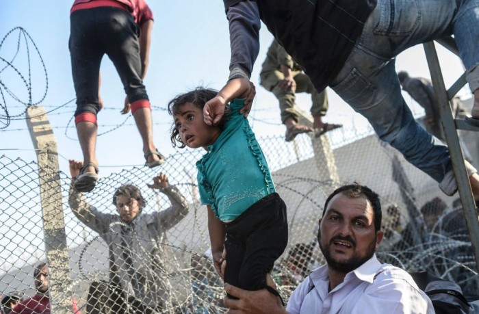 Esta foto, publicada en junio en EL PAÍS y otros medios internacionales, corresponde a uno de los episodios más tensos de la crisis de refugiados sirios. Los asilados entran en Turquia tras romper la valla que le separa de Siria. Es el tercer premio en el apartado de historias TERCER PREMIO EN HISTORIAS DE NOTICIAS DE ACTUALIDAD BULENT KILIC (AFP)