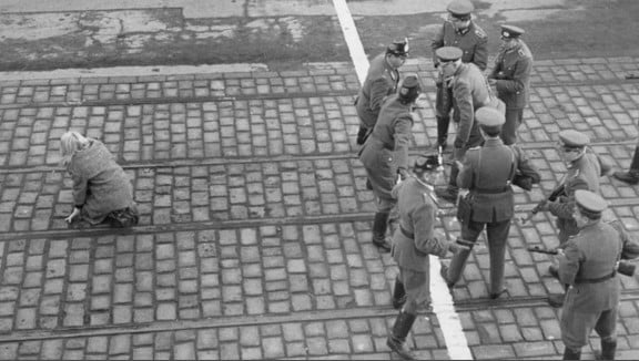 Agentes de la Policía de Alemania Occidental impiden que los guardias fronterizo de Alemania Oriental disparen a una joven que escapó del Estado comunista, antes de la construcción del Muro de Berlín, 1955. Crédito Hispan TV