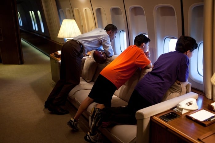 El presidente Obama mira por una ventana del avión “Air Force One” con los hijos de un ayudante durante un vuelo a Hawáii en 2011. (La Casa Blanca)