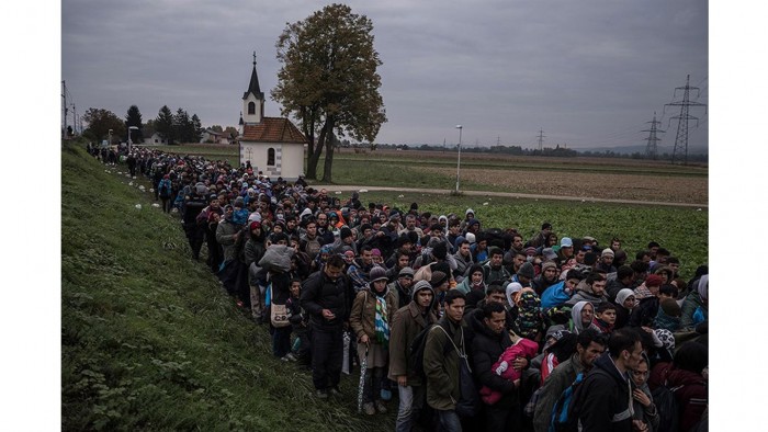 Los migrantes escoltados por la policía antidisturbios Eslovena en un campo de registro fuera de Dobova, Eslovenia. Las pequeñas naciones de los Balcanes a lo largo del camino de la migración a través de Europa han visto un número récord de refugiados cruzando sus fronteras. Foto: Sergey Ponomarev/ The New York Times