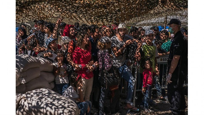 Los refugiados esperan en fila para los documentos en un centro de procesamiento en Presevo, Serbia. Largas filas de personas de pie en el sol abrasador, pidiendo guardias para dejarlos en el centro de recepción. Los refugiados tenían que registrarse para viajar más lejos a través de Serbia. Foto: Sergey Ponomarev/ The New York Times