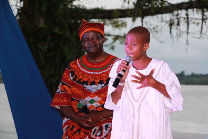 El pequeño Pablo, de 12 años, recitando un poema en honor a su barrio. Atrás, el juglar viajero de Camerún, el maestro Boniface Ofogo, quien también participó en el mano a mano narrativo. Foto Ola Ventura vía Facebook
