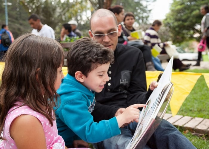 Lectura bajo los árboles del Parque Nacional en Bogotá