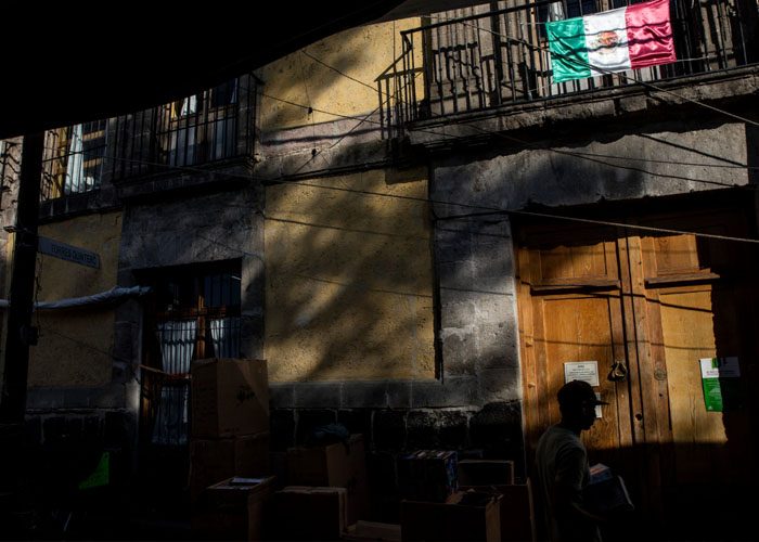 La casa, con grandes puertas de madera, está escondida entre puestos de mercado.