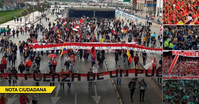 Large street protest with a long banner and many marchers crossing a city avenue, some carrying flags and signs. - La desconfianza se toma el fútbol colombiano entre rumores, apuestas y sospechas