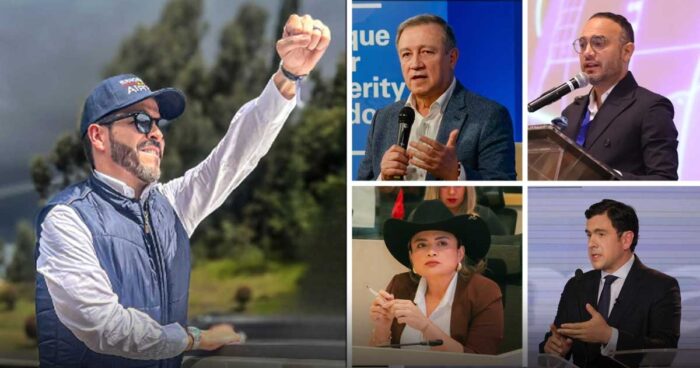 Man in a blue cap and puffer vest raises his fist outdoors, smiling, with trees and hills in the background. - Las2orillas.co: Historias, voces y noticias de Colombia