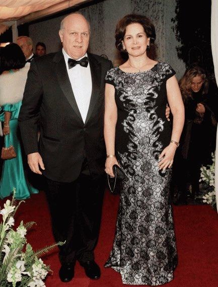 A man in a black tuxedo and a woman in a black and silver lace gown pose on a red carpet at a formal event. - Los 5 grandes medios de comunicación de Colombia perdieron millones en el 2025 