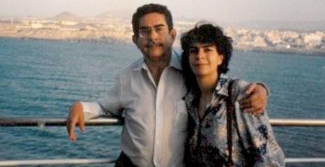 Two people posing side by side with arms around each other on a railing by the sea, with a distant shoreline in the background. - El lado costeño de Iván Cepeda por su abuela Aurita Chadid que lo hace familia de los Guerra, los Name y otros