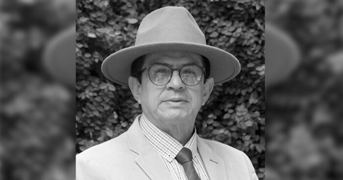 Portrait of an older man in a wide-brim hat, glasses, plaid shirt, and light suit outdoors. - Las2orillas.co: Historias, voces y noticias de Colombia