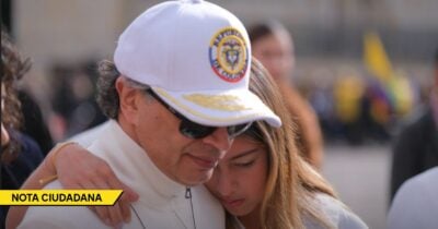 Man wearing a white cap and sunglasses hugs a young woman at a crowded event, with a yellow 'NOTA CIUDADANA' banner in the corner. - Las2orillas.co: Historias, voces y noticias de Colombia