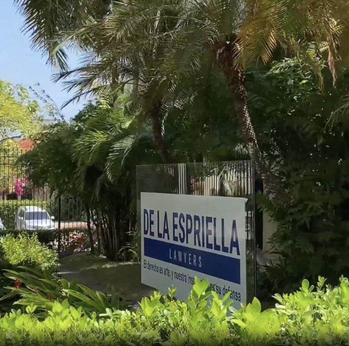 Sign for 'DE LA ESPRIELLA LAWYERS' displayed outdoors among palm trees and greenery - Yoly Pimienta, la primera esposa de Abelardo De la Espriella, con quien se casó a los 23 años