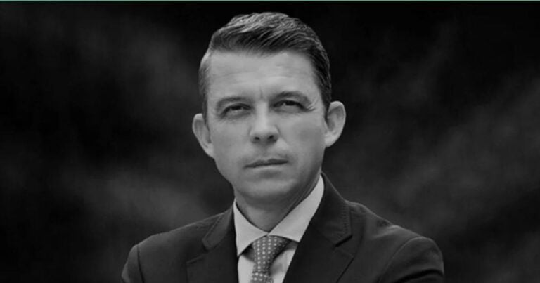 Black-and-white portrait of a man in a suit and tie, facing the camera with a neutral expression. - El panorama es crítico, confiemos en las autoridades