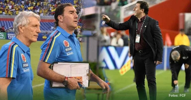 Two soccer coaches in blue shirts on the sideline, clipboard in hand, watching a match unfold. - Las2orillas.co: Historias, voces y noticias de Colombia