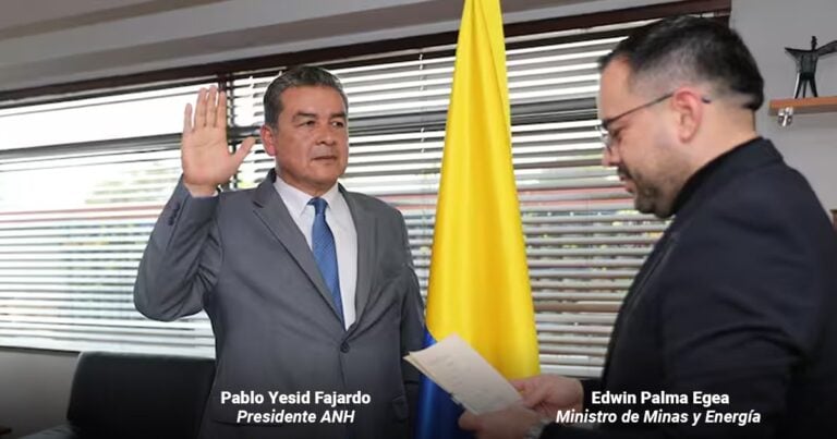 Oath moment: Pablo Yesid Fajardo raises his right hand while Edwin Palma Egea reads from a document beside a yellow flag in a formal office setting to mark his inauguration as ANH president. - Las2orillas.co: Historias, voces y noticias de Colombia