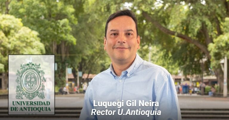 Portrait of Luquegi Gil Neira, Rector U. Antioquia, standing outdoors on campus with the university crest/logo visible on the left. - Las2orillas.co: Historias, voces y noticias de Colombia