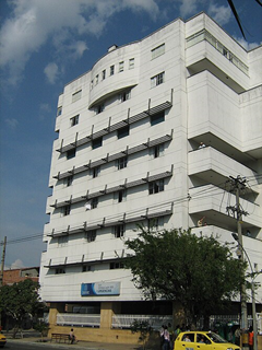 Las deudas con las EPS tienen contra las cuerdas a varias clínicas White multi-story apartment building with rounded bay windows on the top floor and striped balconies, viewed from the street. - Las deudas con las EPS tienen contra las cuerdas a varias clínicas