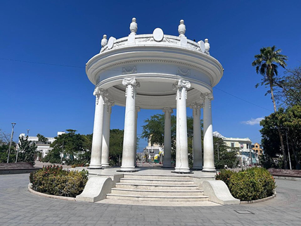 White circular gazebo with tall columns and a domed roof in a sunny city square. - Con el sector privado detrás Ciénaga tendrá puerto moderno y moverá la carga del tren