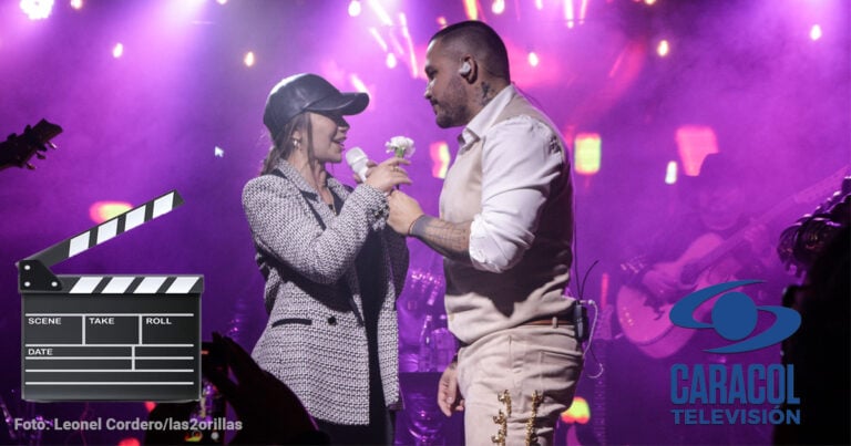 Las2orillas.co: Historias, voces y noticias de Colombia Two singers on a purple-lit stage share a microphone, the man offering a flower to the woman during a duet. - Las2orillas.co: Historias, voces y noticias de Colombia