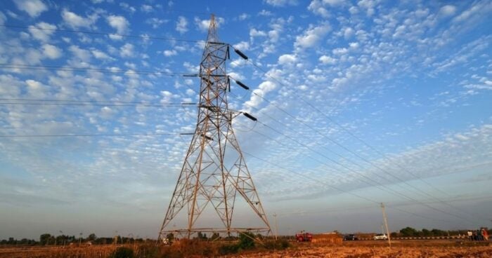 Juan Ricardo Ortega y su poderosa junta convirtieron al Grupo Energía de Bogotá en un poderoso jugador en elBrasil Tall metal lattice electricity pylon with high-voltage power lines stretching across a desert landscape under a blue sky with scattered clouds. - Juan Ricardo Ortega y su poderosa junta convirtieron al Grupo Energía de Bogotá en un poderoso jugador en elBrasil