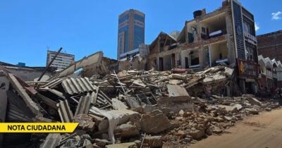 Rubble and collapsed buildings on a street after a collapse, with debris scattered and a tall building in the background; a yellow “NOTA CIUDADANA” banner is visible in the lower left corner. - Las2orillas.co: Historias, voces y noticias de Colombia