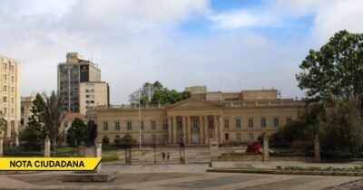Beige neoclassical government building with columns, a gated plaza, and a statue in a surrounding park. - Las2orillas.co: Historias, voces y noticias de Colombia