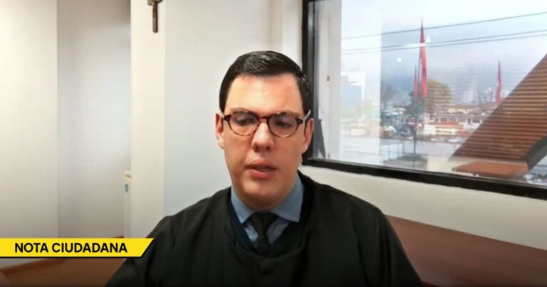 Man in glasses wearing a dark robe sits at a desk in an office; yellow banner in corner reads NOTA CIUDADANA, indicating a citizen news segment. - De no ser aceptado en los colegios a manejar los casos más peligrosos del país: el juez que venció la parálisis