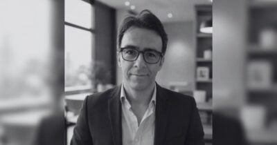 Terremoto en Pereira, después de los titulares Black-and-white photo of a man in a blazer and glasses posing in a modern office - Terremoto en Pereira, después de los titulares