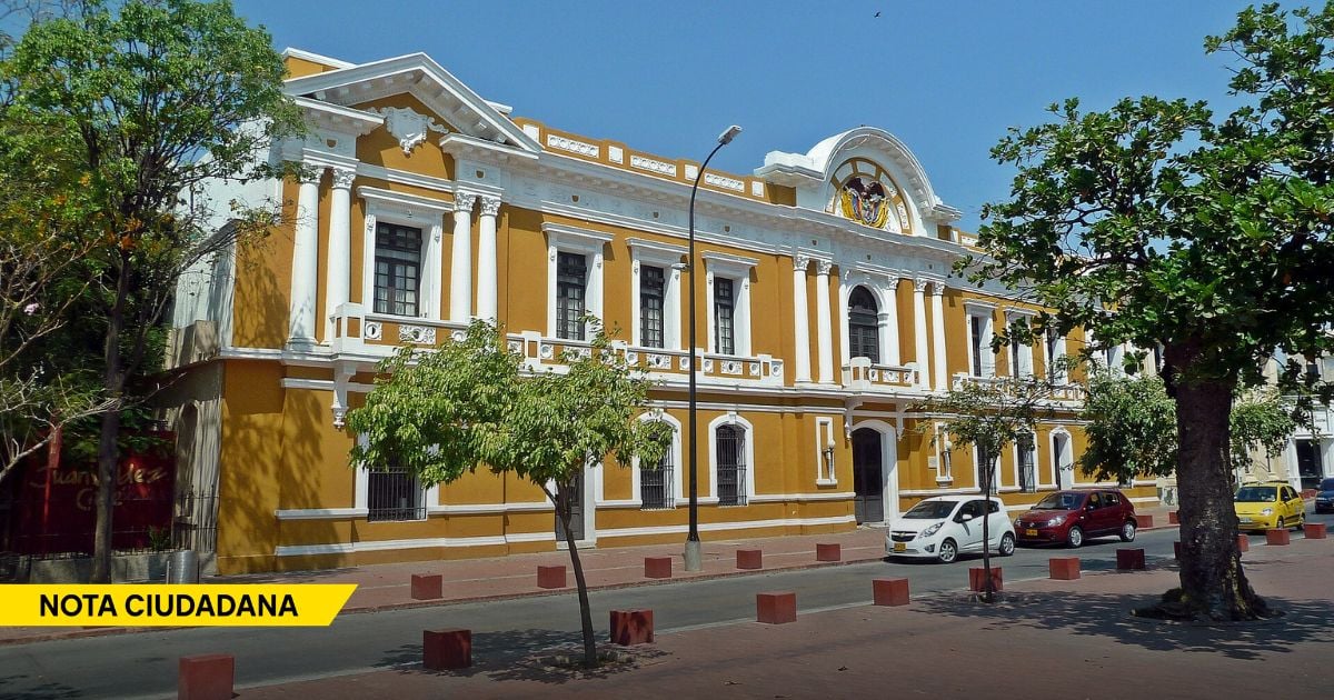 Historic yellow and white neoclassical building with tall columns on a sunny street, with trees and parked cars in front. - El portazo de un juez a la Alcaldía de Santa Marta por esconderle contratos a un periodista