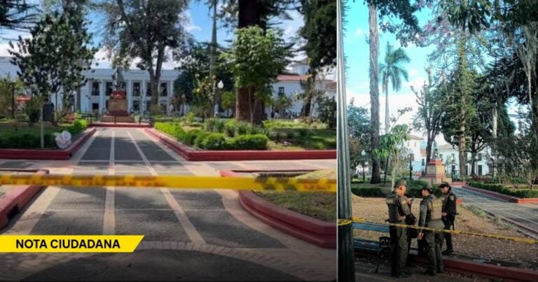 Park scene with yellow caution tape blocking a walkway and a white building in the background; trimmed hedges and a central path suggest a restricted area (note ciudadana watermark). - En plena ola de calor, la Alcaldía de Popayán cerró el único parque con sombra de la ciudad