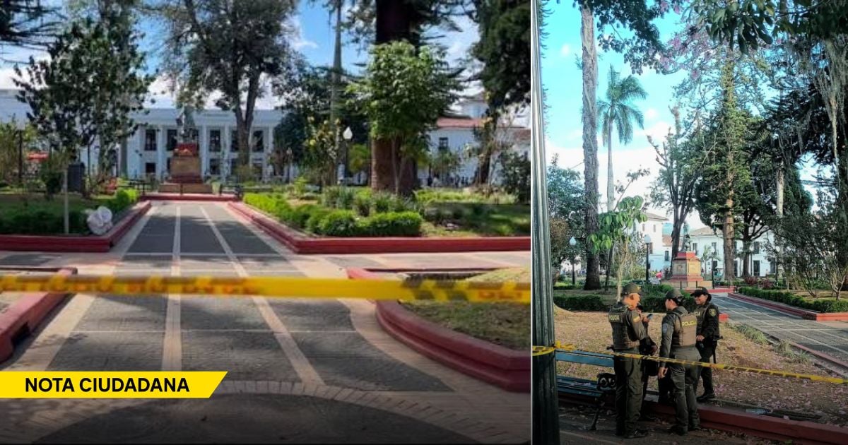 Park scene with yellow caution tape blocking a walkway and a white building in the background; trimmed hedges and a central path suggest a restricted area (note ciudadana watermark). - En plena ola de calor, la Alcaldía de Popayán cerró el único parque con sombra de la ciudad
