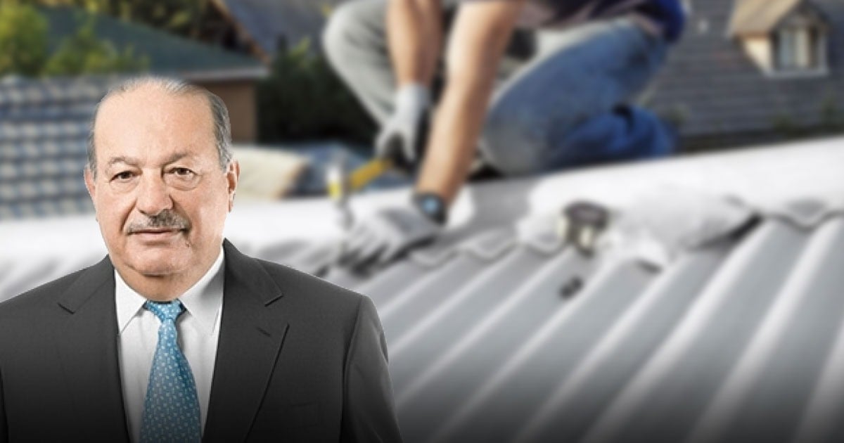 Businessman in a suit stands in foreground with workers installing a metal roof in the background. - Con Eternit para casas en Buenaventura el millonario Carlos Slim se une a la reconstrucción