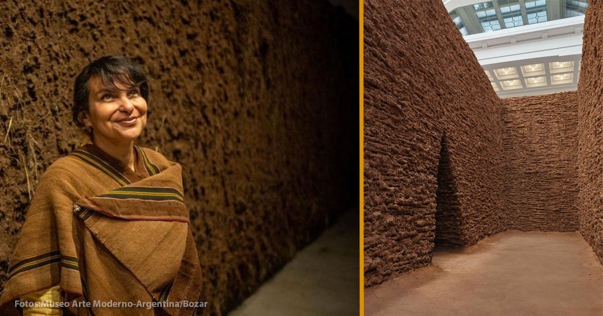 Split-image: a smiling woman in a brown poncho stands in a dim earthen-walled corridor on the left; on the right, tall clay brick walls form a labyrinth in a bright indoor space. - La cordobesa Delcy Morelos se despide del Palacio de Bellas Artes de Bruselas con una obra hecha con tierra de Bélgica