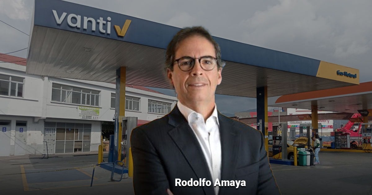 Professional man in a dark suit standing at a gas station, with a blue Vanti sign in the background. - La fórmula del presidente de Vanti para asegurar que no habrá escasez de gas