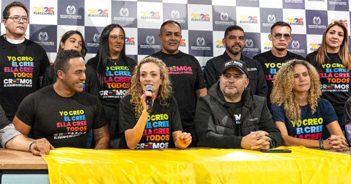 El espaldarazo de Fico Gutiérrez que metió a la Profe cordobesa Natalia López en el gabinete del Tigre Grupo de diversos oradores en una conferencia de prensa, sentados detrás de un banner amarillo; una mujer en el centro habla en un micrófono, todos con camisetas negras con texto colorido.