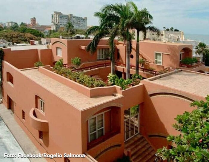 Adiós a la casa de Gabo donde recibió la noticia del Nobel y murieron él y Mercedes en Ciudad de México Pink stucco residential complex with terraces and a rooftop garden, palm trees at the center. - Adiós a la casa de Gabo donde recibió la noticia del Nobel y murieron él y Mercedes en Ciudad de México
