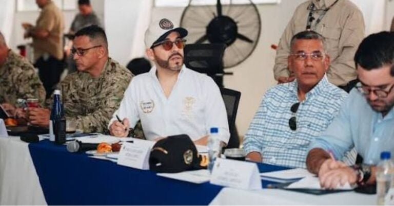 Las2orillas.co: Historias, voces y noticias de Colombia Panel of military and civilian officials seated at a long conference table, one man in a light blue shirt taking notes. - Las2orillas.co: Historias, voces y noticias de Colombia