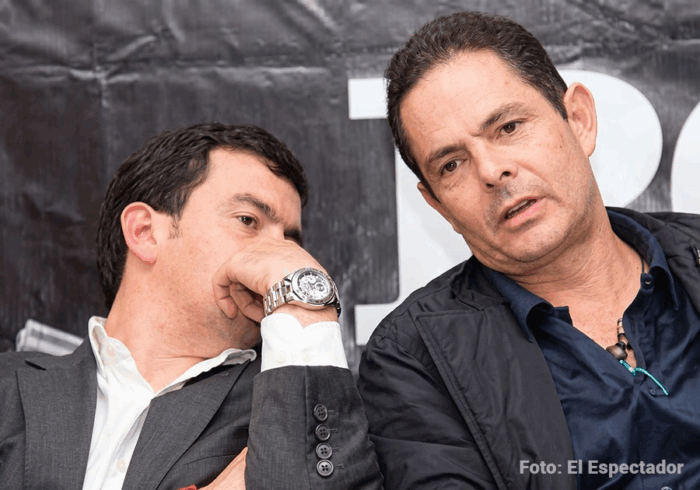 A excepción de minHacienda y el Canciller, todos los ministros de De la Espriella llegan endeudados Two men lean toward each other in a close conversation at an event; one wears a gray suit and white shirt, the other a dark jacket. - A excepción de minHacienda y el Canciller, todos los ministros de De la Espriella llegan endeudados