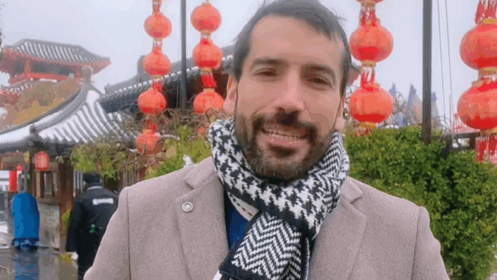 Man smiling for a selfie at a lantern festival, with red lanterns and traditional rooftops behind him. - Quiénes están en los mejores oficinas de Procolombia en el exterior que El Tigre va a acabar