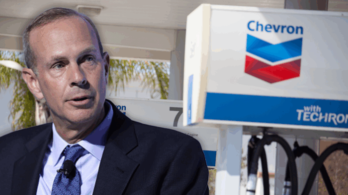 Un poderoso bufete manejará los contratos de las empresas que explotarán el petróleo venezolano A man in a dark suit and purple tie stands beside a Chevron gas pump with Techron branding. - Un poderoso bufete manejará los contratos de las empresas que explotarán el petróleo venezolano