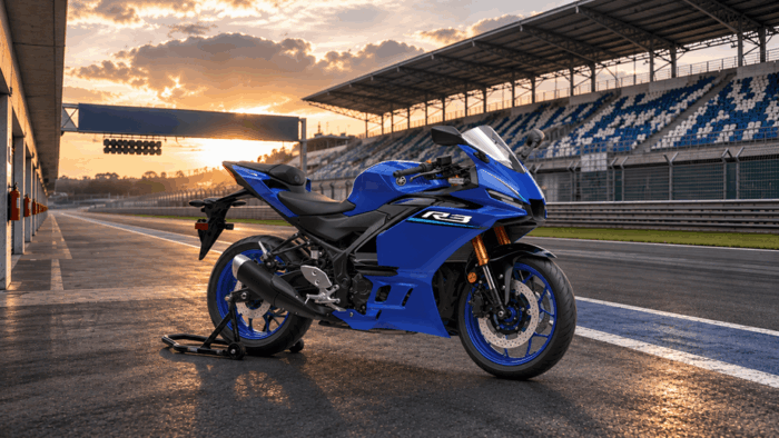 Yamaha sacó del trancón a 250 motociclistas y los puso a correr en el Autódromo de Tocancipá Blue Yamaha R3 sport motorcycle parked on a race track pit lane at sunset, with grandstands in the background. - Yamaha sacó del trancón a 250 motociclistas y los puso a correr en el Autódromo de Tocancipá