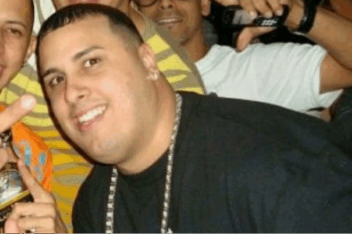 Smiling man in a black shirt with a silver chain posing for a group selfie at a party - La segunda oportunidad en Colombia que sacó a Nicky Jam de la pobreza y lo volvió un gigante del reguetón