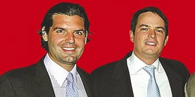 La opulenta vida del venezolano escogido de Trump para hacer los negocios de las petroleras gringas Two men in business suits standing side by side, smiling, against a bright red backdrop. - La opulenta vida del venezolano escogido de Trump para hacer los negocios de las petroleras gringas