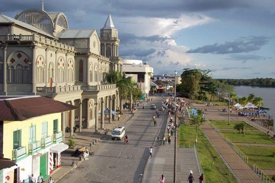 Don Rey, el músico de Quibdó que cambió las armas por instrumentos a cientos de jóvenes del Chocó Prominent riverfront street with ornate colonial buildings, palm trees, and people strolling along the waterfront park behind them. - Don Rey, el músico de Quibdó que cambió las armas por instrumentos a cientos de jóvenes del Chocó