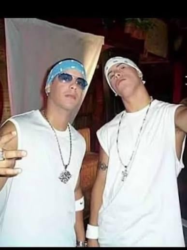Two young men in white sleeveless shirts and bandanas pose for a selfie, wearing accessories and sunglasses. - La segunda oportunidad en Colombia que sacó a Nicky Jam de la pobreza y lo volvió un gigante del reguetón