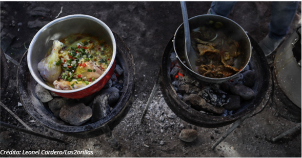 Una empresa colombiana es la única que con sus pipetas le pelean a 4 gigantes chilenas en el negocio de gas propano Two metal pots cooking over a charcoal fire outdoors; left pot holds a brothy vegetable soup, right pot contains meat stew with a ladle. - Una empresa colombiana es la única que con sus pipetas le pelean a 4 gigantes chilenas en el negocio de gas propano