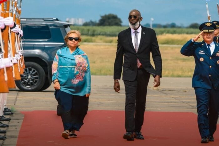 Así fue la llegada a Cali de presidentes e invitados especiales a la posesión de Abelardo De la Espriella A man in a suit and a woman in a turquoise top walk down a red carpet as uniformed soldiers salute on the right at an airport tarmac. - Así fue la llegada a Cali de presidentes e invitados especiales a la posesión de Abelardo De la Espriella