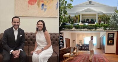 Las2orillas.co: Historias, voces y noticias de Colombia Man in a dark suit and a woman in a white dress sit on a brown tufted sofa indoors, smiling at the camera. - Las2orillas.co: Historias, voces y noticias de Colombia