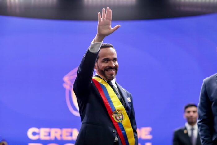 De dónde viene “Viva Cristo Rey” la frase con la que De la Espriella termina toda intervención política Man in a suit waving with a Colombian flag sash at a ceremony, smiling against a blue backdrop. - De dónde viene “Viva Cristo Rey” la frase con la que De la Espriella termina toda intervención política