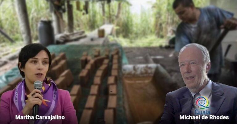 Las2orillas.co: Historias, voces y noticias de Colombia Two speakers are shown in front of a construction site with brick stacks; a woman on the left holds a microphone as if speaking, a man in a suit sits on the right smiling. - Las2orillas.co: Historias, voces y noticias de Colombia